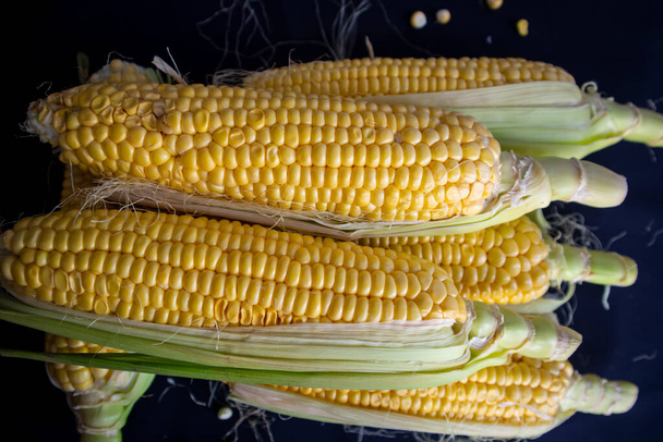 Ízletes friss kukorica fekete elszigetelt háttér nézet - Fotó, kép