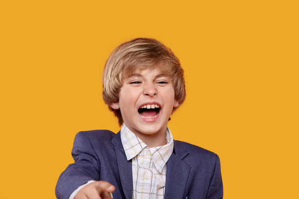 Laughing boy blond points his finger at the camera. ridicule - Foto, Imagen