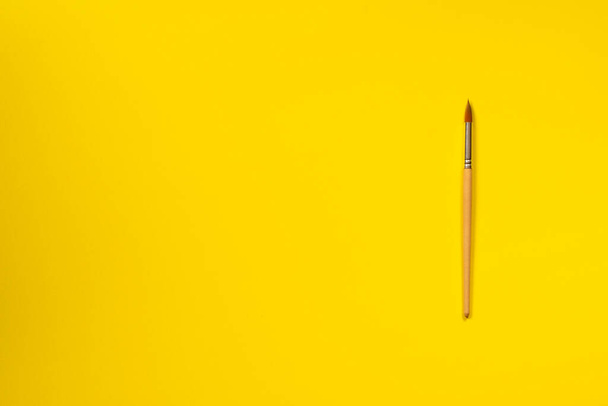 single isolated paint brush flat lay top view yellow background - 写真・画像