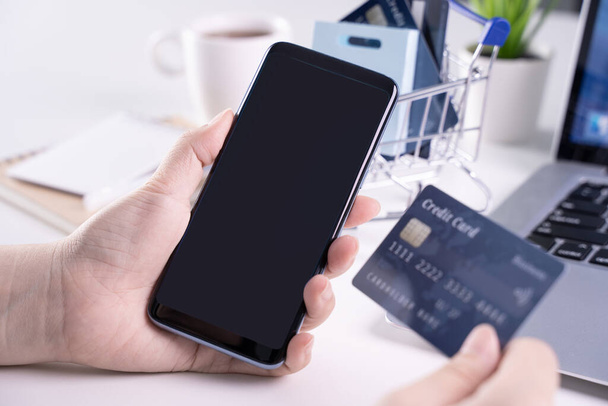 Office online paying, stay home shopping, electronic payment with credit card concept, laptop on white table background with shop cart, close up. - Foto, afbeelding