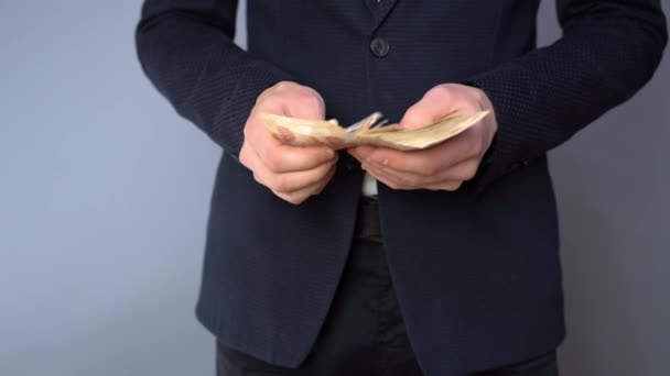 Businessman counting Russian banknotes. Man in blue suit counts money from a pack of bills - Séquence, vidéo