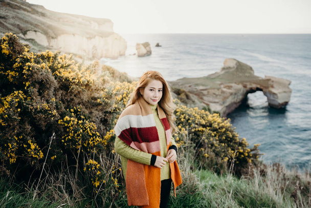 Krásná asijská žena návštěva na Tunel Beach s východem slunce, Otago Peninsula, Nový Zéland. - Fotografie, Obrázek