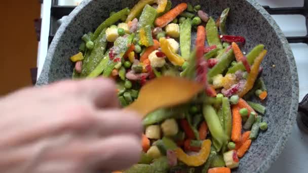 Zamrożone warzywa na parze w patelni miesza się łopatkę - Materiał filmowy, wideo