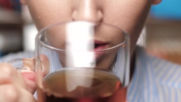 Woman is drinking tea. Female hands bring mug to mouth and drink black tea - Video, Çekim