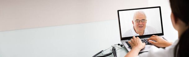 Доктор разговаривает с пациентом через видео чат на ноутбуке на рабочем столе
 - Фото, изображение
