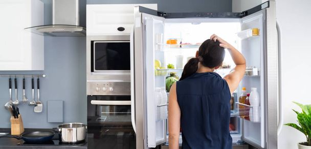 Hungry Women Looking At Food Inside Fridge - Photo, image