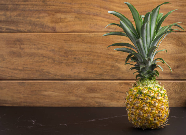 Pineapple on a table with wooden background. - Photo, image
