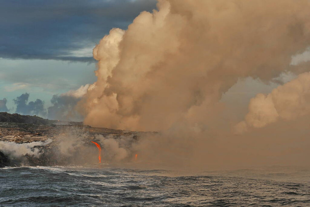 La lava volcánica fluye en las olas oceánicas
 - Foto, imagen