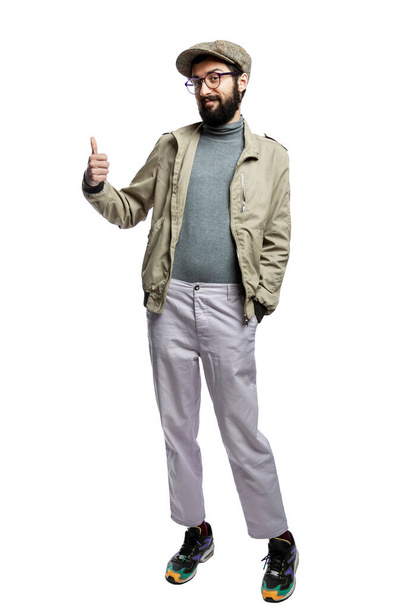 Stylish young man in glasses and with a beard holds a thumbs up. Isolated on a white background. Vertical. - Фото, зображення