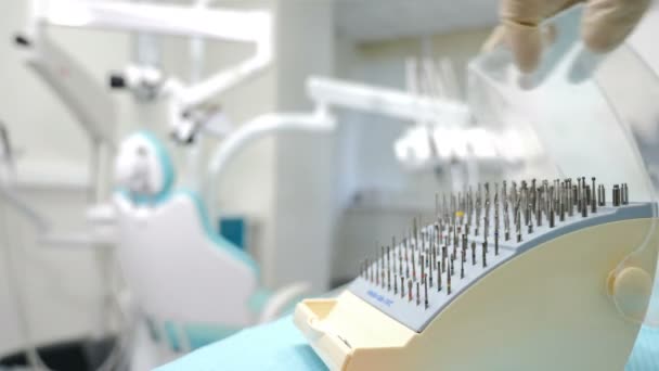 Au cabinet dentaire. Docteur main dans le gant d'ouverture des burs de diamant dentaire dans une boîte transparente spéciale avec fond de bokeh flou dans l'armoire dentaire. concept médical et de santé. Vidéo 4 k
 - Séquence, vidéo