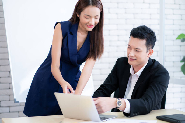 ビジネスカップルは、ラップトップコンピュータ、現代のオフィスで働く笑顔 - 写真・画像