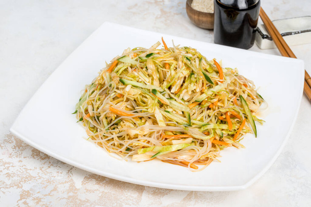 Chinese salad of fresh vegetables, noodles, cabbage in a white plate - Foto, imagen