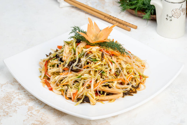 Chinese salad of fresh vegetables, noodles, cabbage in a white plate - Fotoğraf, Görsel