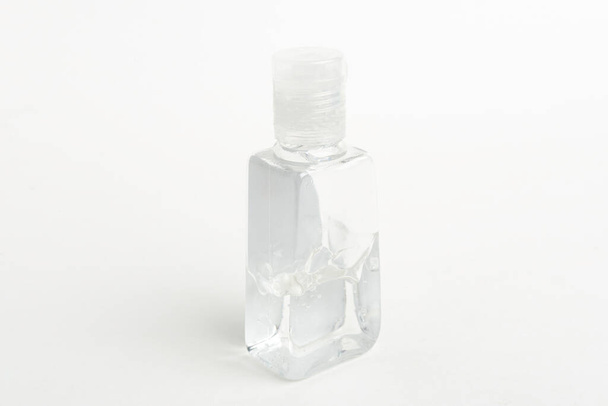 Una toma de producto de una botella de dispensador de plástico desinfectante de mano transparente de tamaño bolsillo genérico sobre un fondo blanco liso
. - Foto, Imagen