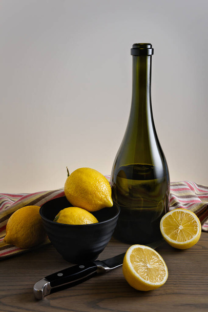 Lemons and bottle with lemonade on the table. - Photo, image