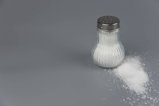 Una pila de sal de salero, concepto de ingesta excesiva de sal y muerte blanca
 - Foto, imagen