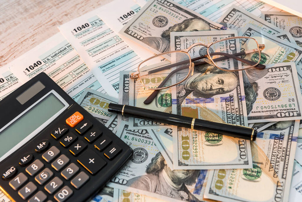 1040 налоговая форма на столе с ручкой калькулятор и нам доллар. бизнес концепция. - Фото, изображение