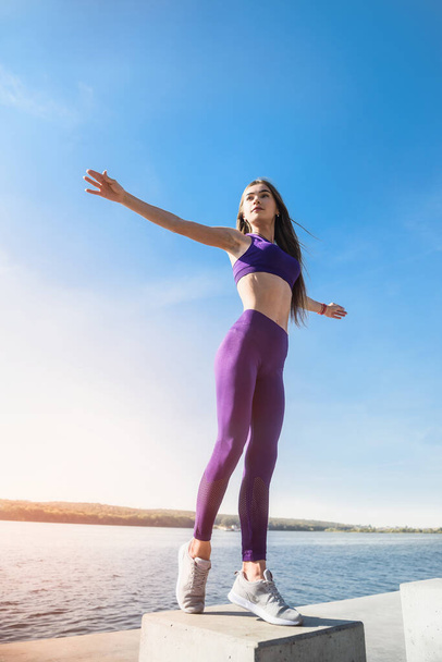 Spor yapan kadın gündüz vakti gölün yanındaki parkta yoga egzersizi yapıyor. Sağlıklı yaşam tarzı kavramı - Fotoğraf, Görsel