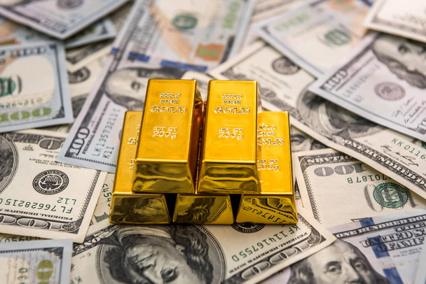 Goud bij Amerikaanse dollar bankbiljetten close-up - Foto, afbeelding