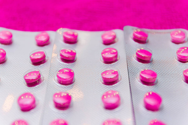 sada barevných léků pilulky na růžové pozadí, koncept lékařské diagnózy a terapie - Fotografie, Obrázek