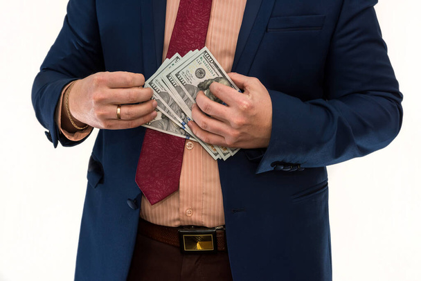 Деловой человек держит и считает деньги. Доллар в мужской руке, изолирован на белом. Концепция экономии - Фото, изображение