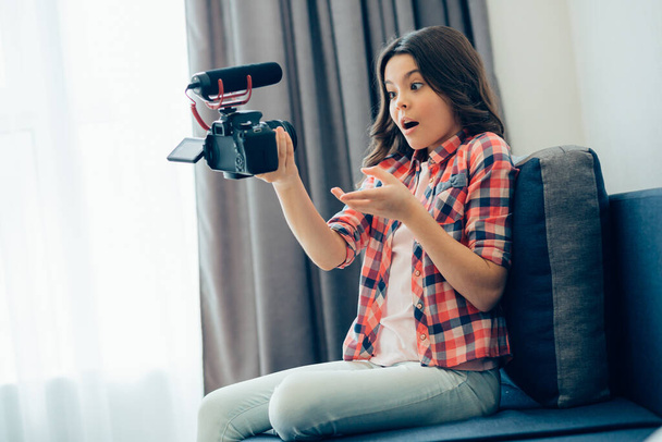 Експресивна дівчина-підліток має свій блог і робить відео для нього вдома, сидячи на дивані
 - Фото, зображення