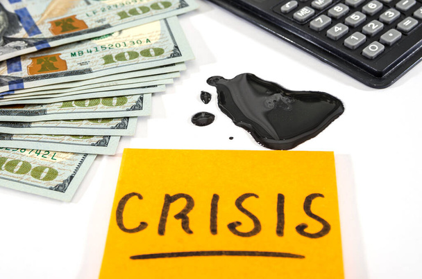 Oil crisis concept. Crude oil with dollars and a calculator on white. - Photo, Image