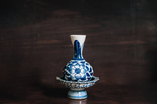Πολύχρωμο μπλε δίσκο βάθρο και βάζο λουλούδι Κίνα ware, κινεζική πορσελάνη σε ξύλινο φόντο - Φωτογραφία, εικόνα