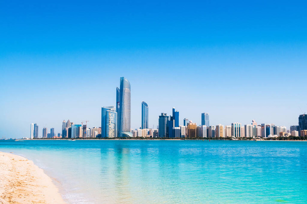 Abu Dhabi sky line and city scene shots from white sand beach on marina island - Photo, Image