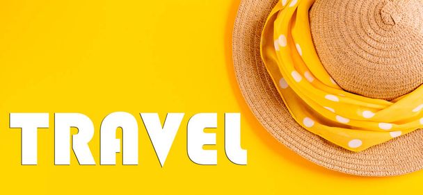 The word travel written in letters on a yellow background with a straw hat. The concept of rest, vacation. Banner. - Photo, Image