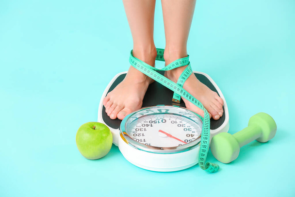 Jeune femme mesurant son poids sur fond de couleur
 - Photo, image