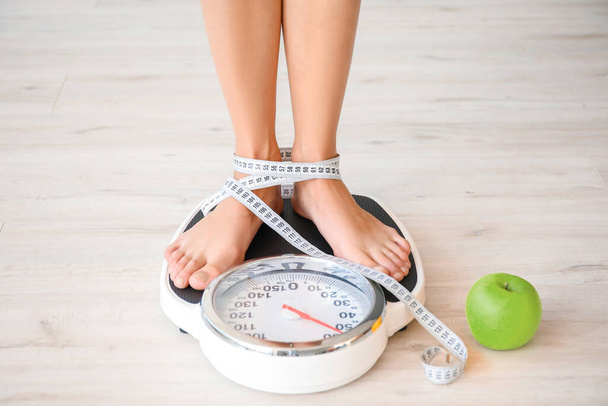 Jeune femme mesurant son poids à la maison
 - Photo, image