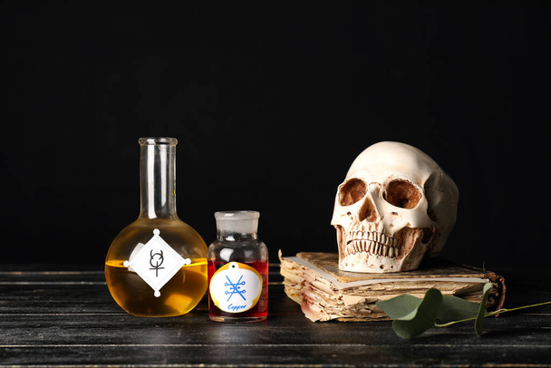 Potions, human skull and old book on alchemist's table - Photo, Image