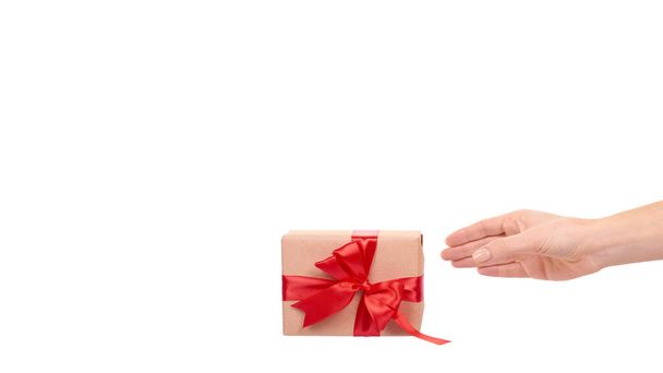 Hand with gift box, wrapped with brown paper. Isolated on white background. Copy space, template. - Fotoğraf, Görsel