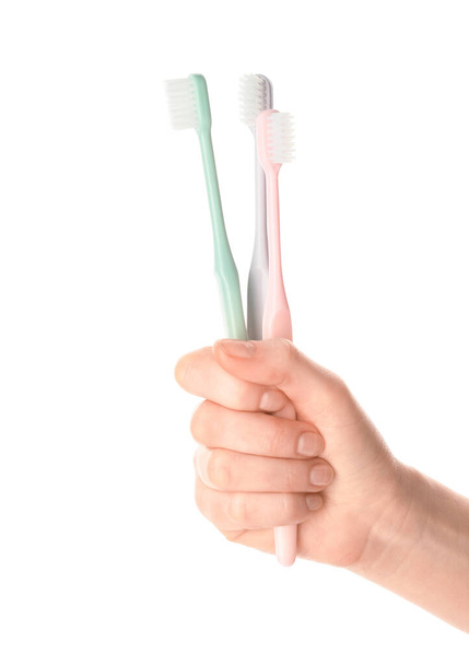 Vrouwelijke hand met tandenborstels op witte achtergrond - Foto, afbeelding