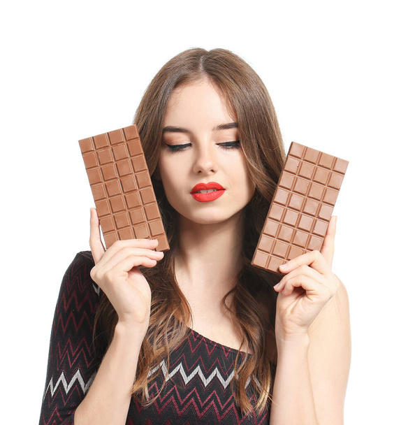 Beyaz arka planda lezzetli çikolataları olan güzel genç bir kadın. - Fotoğraf, Görsel