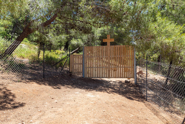 Außenzaun mit einem großen Holzkreuz, das das Kloster Lavra Netofa in der Nähe des Dorfes Hararit in Nordisrael umgibt - Foto, Bild