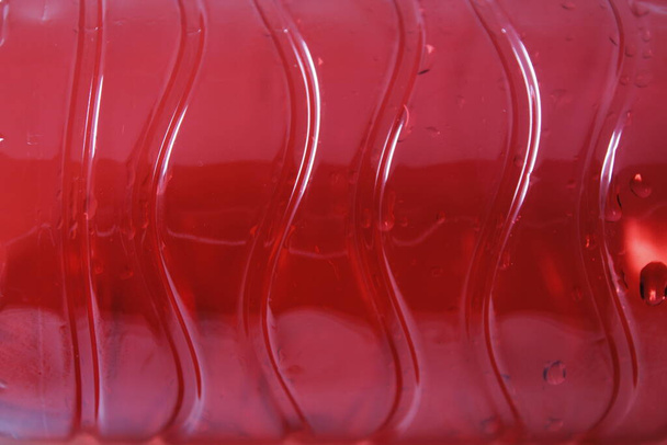Rode plastic fles in witte achtergrond - Foto, afbeelding