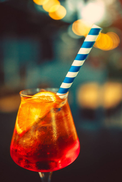 Glass of Aperol Spritz and blue straw, Italian Cocktail. Fine film grain texture. - Photo, image