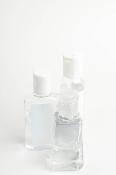 Un cliché de trois flacons génériques en plastique nettoyant transparent pour les mains de poche posés sur un fond blanc uni
. - Photo, image