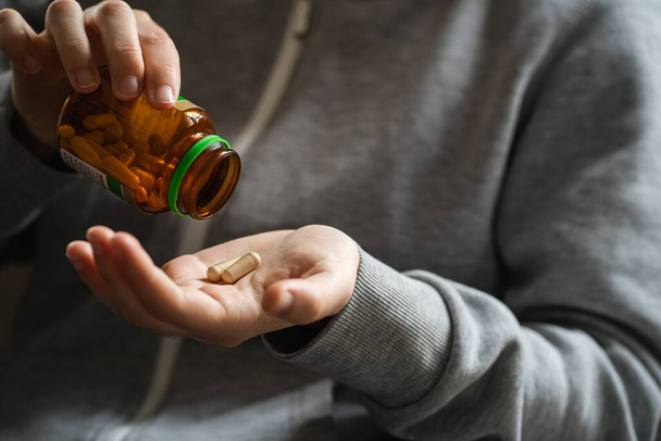 The bottle of medical pills in the hands of a person - Valokuva, kuva