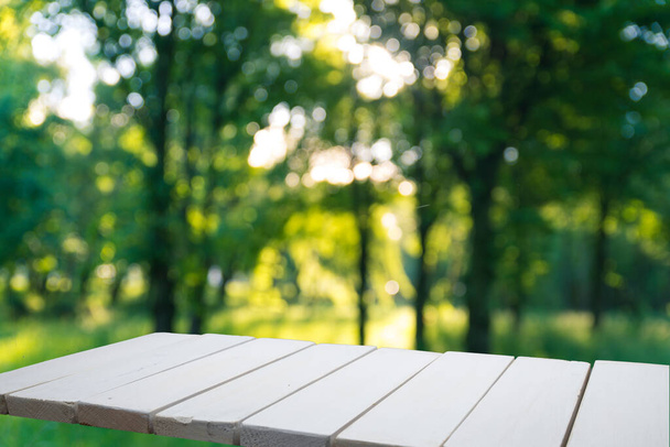 Empty wooden deck table with park bokeh background. - Photo, image