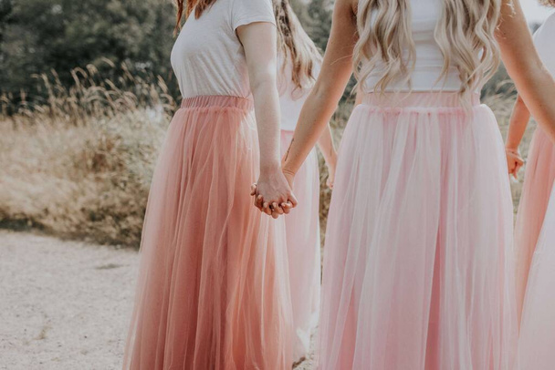The young girls in beautiful dresses holding hands - 写真・画像