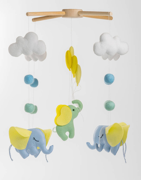 Kolorowe i ekologiczne mobilne dziecięce z filcu dla dzieci. Składa się ze słonia, chmur i balonów zabawek. Ręcznie robione na szarym tle. - Zdjęcie, obraz