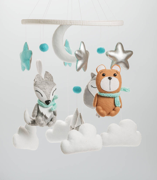 Colorful and eco-friendly children's mobile from felt for children. It consists of bear, fox, owl, rabbit, mountain, stars, clouds and balloons toys. Handmade on gray background. - Photo, Image