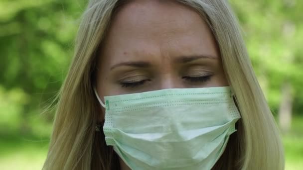Sad, upset young woman in a medical mask. Sad girl in a protective mask - Felvétel, videó