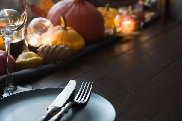 Fall dark place setting with pumpkins, autumn harvest, apples, cone,dry maple leaves. Horizontal orientation with copy space. Centerpieces Thanksgiving Day. Close up. - Foto, Imagen