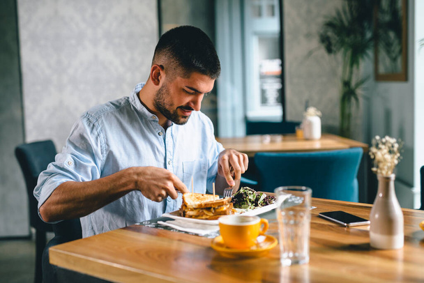 young man eating alone in restaurant - Zdjęcie, obraz