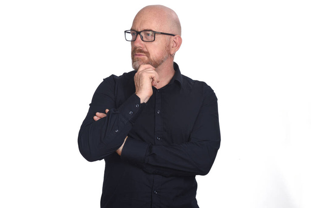 portrait d'un homme avec des lunettes regarder le côté et la main sur le menton sur fond blanc
 - Photo, image