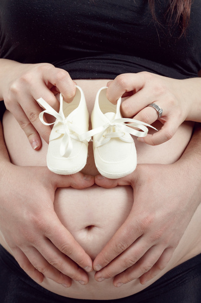 pregnant woman with a child's shoe - Photo, Image